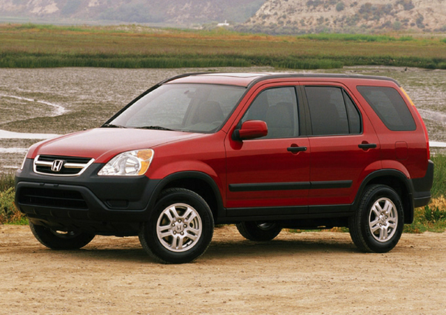 a 2004 honda cr-v parked on the sand next to a river