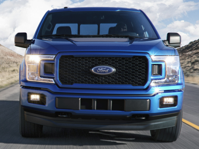 a 2020 blue ford f-150 platinum edition driving on a highway
