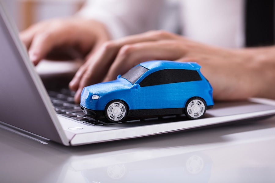 a small blue car on a laptop