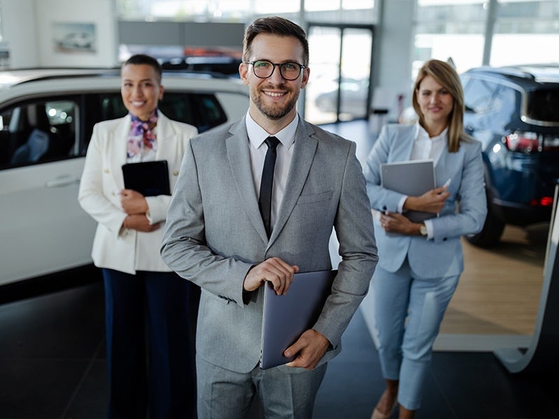 stock dealership photo with salesmen next to vehicles
