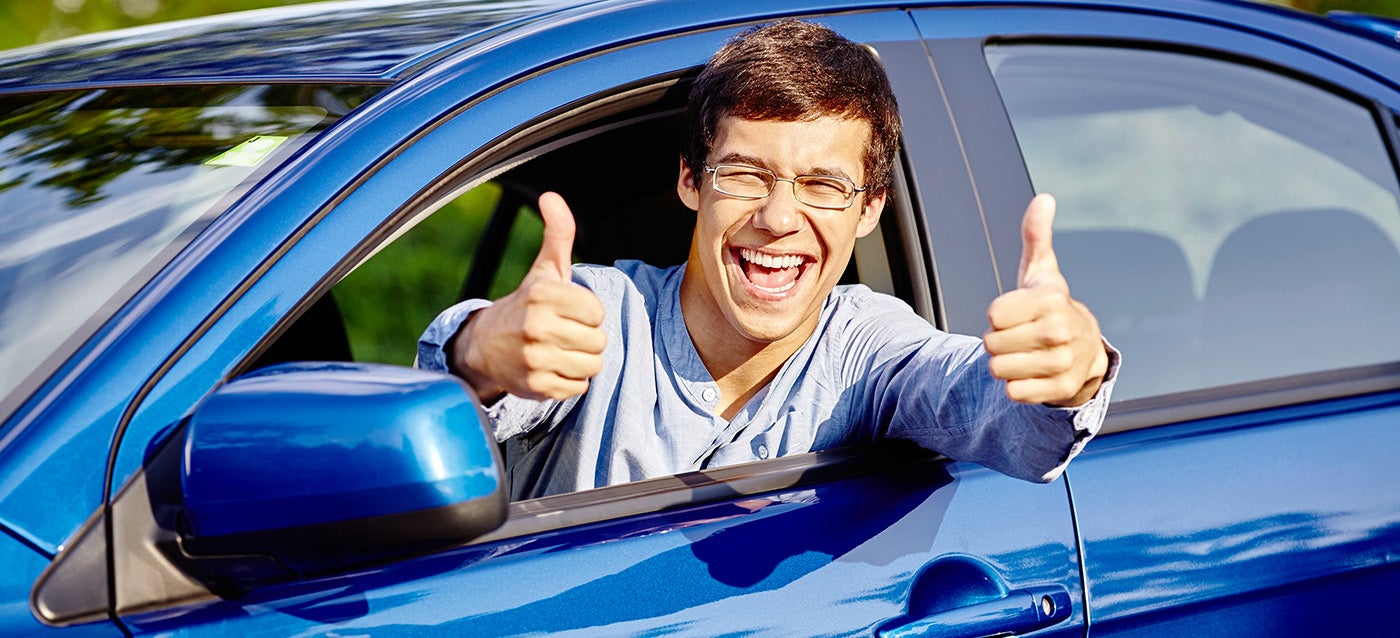 college student in a vehicle with thumbs up