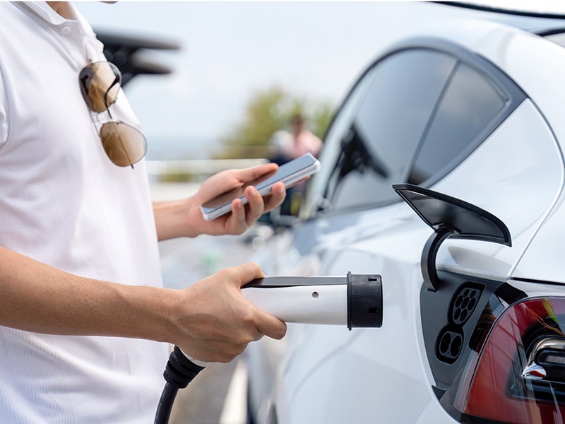 a person charging an electric vehicle
