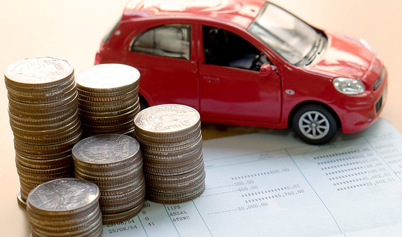 a red toy car next to a stack of quarters