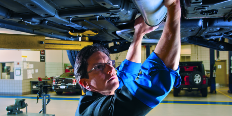 a mechanic working on the exhaust of a vehicle