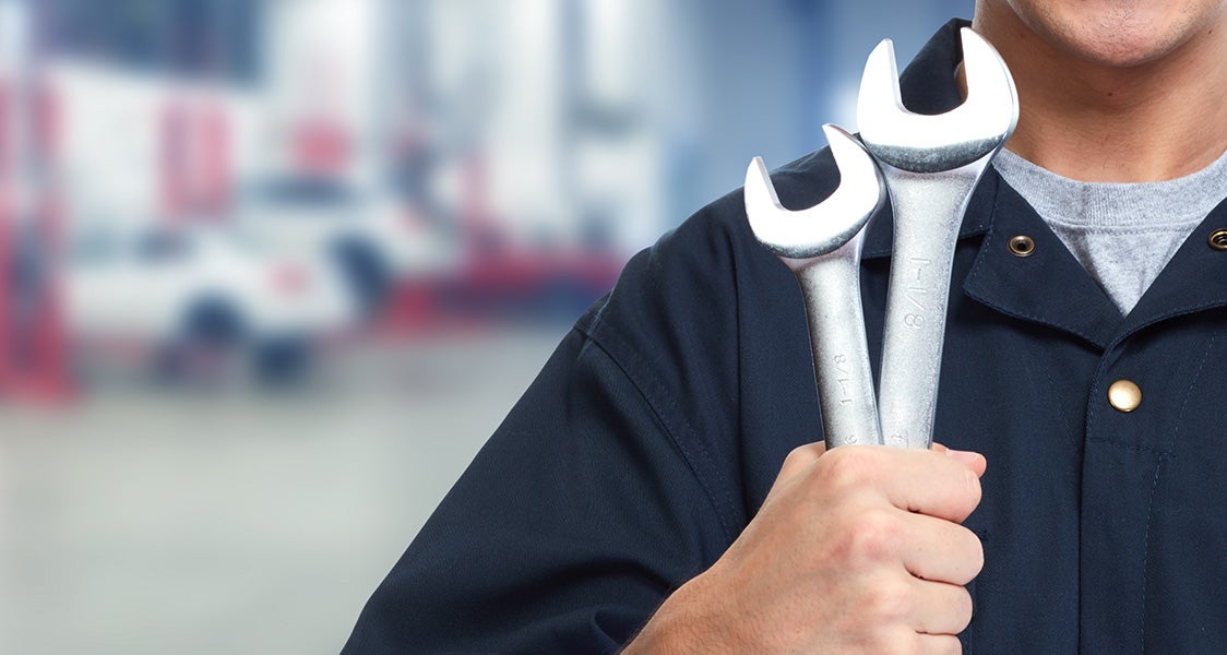 a service tech holding 2 wrenches