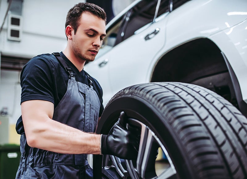 a service tech replacing a tire on a vehicle